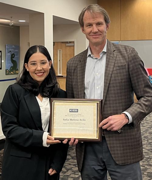 Sofia Avila (left) and Durham Tech President J.B. Buxton during the presentation of her award at the Executive Leadership Team meeting.