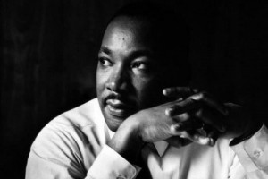 Black and white photograph of Dr. Martin Luther King, Jr. with his hands clasped in front of him