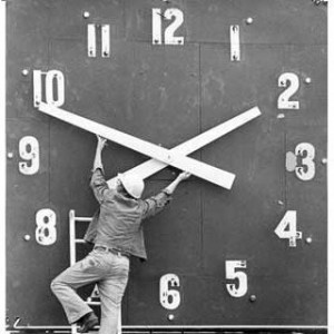 Image of a workman adjusting the hands on a large clock 
