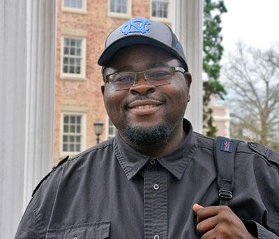man standing on campus smiling at camera
