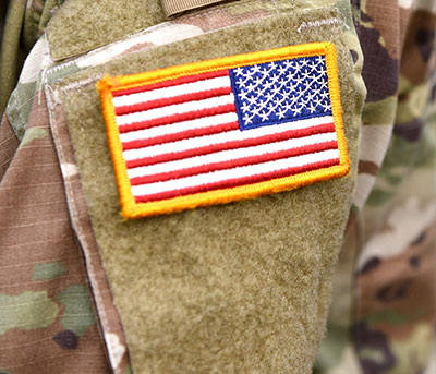 close up of US flag patch on a camouflage military uniform