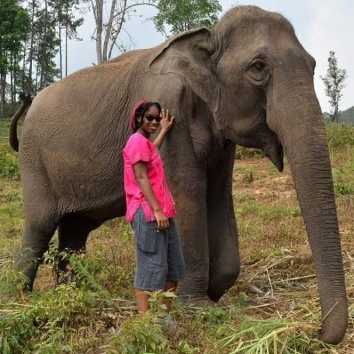 Jonitka standing in front of elephant in field