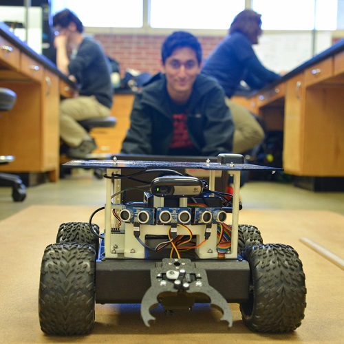 close up of rover and student sitting behind it smiling