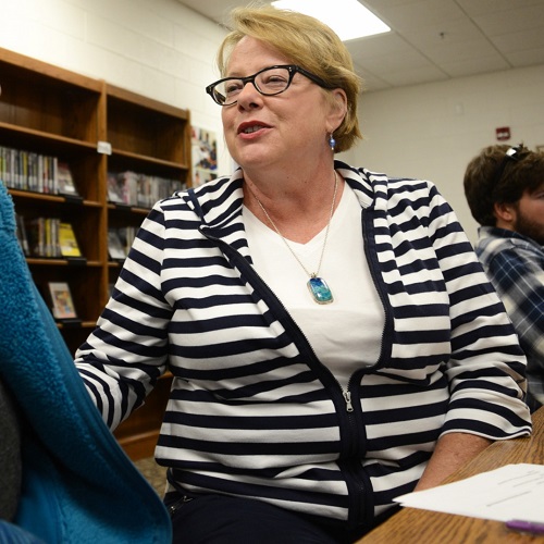 student smiling at Mary Moore while sitting in library on Orange County Campus