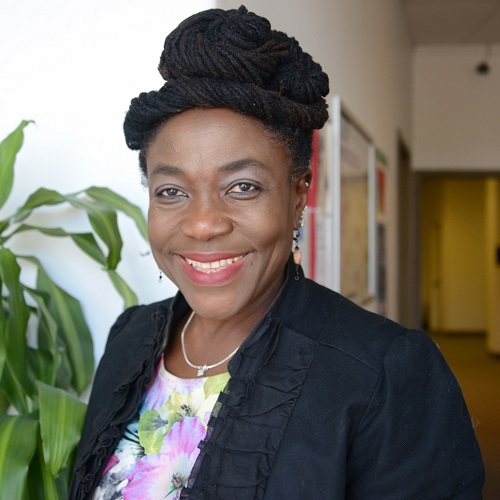 headshot of valerie in her office foyer with plant behind her