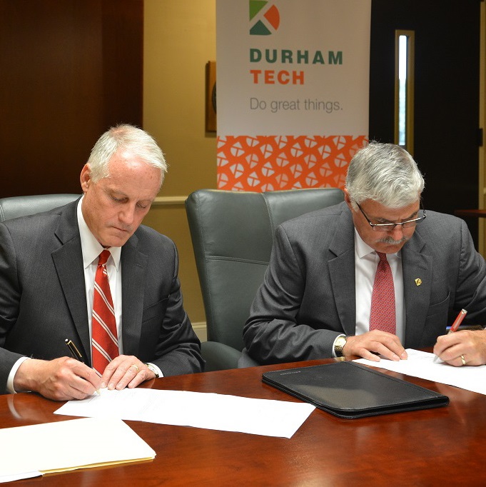 Dr. Louis Hunt, Senior Vice Provost of Enrollment Management Services at NC State, and Dr. Bill Ingram, President of Durham Tech, sign NC State C3 agreement