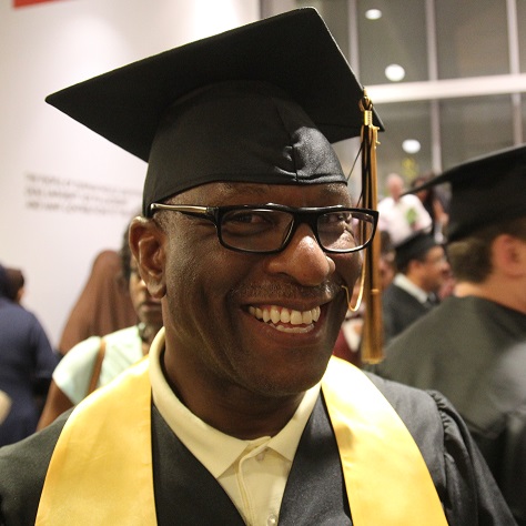 smiling graduate in cap and gown