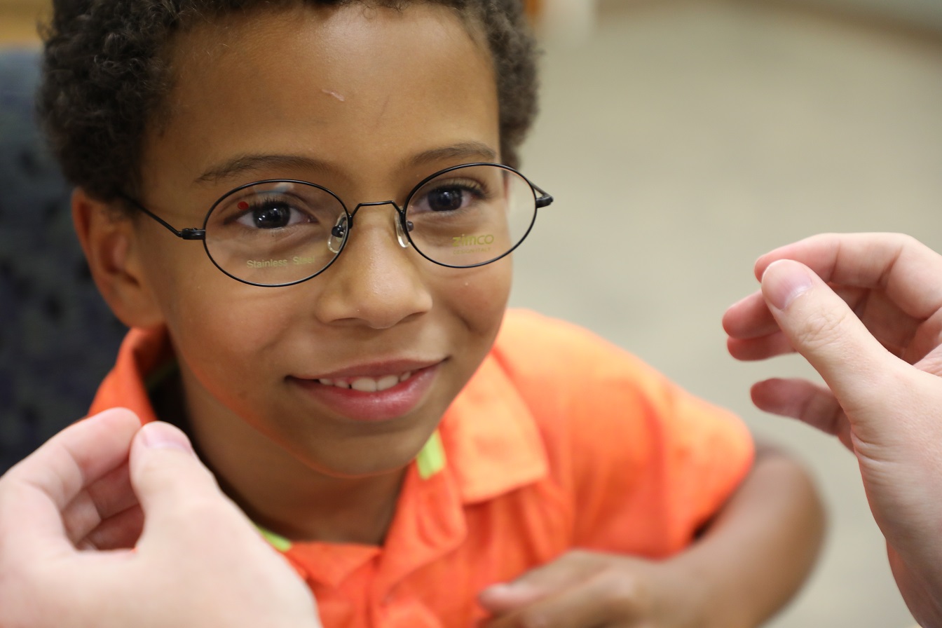 young child wearing glasses and smiling