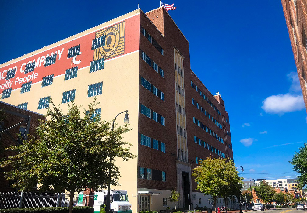 tall building on main street with two trees on either side, blue skies