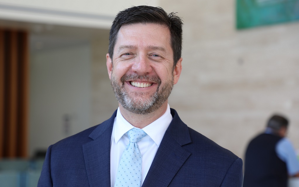 headshot of jeff strickler inside lobby of hillsborough hospital wearing blue coat and light blue tie