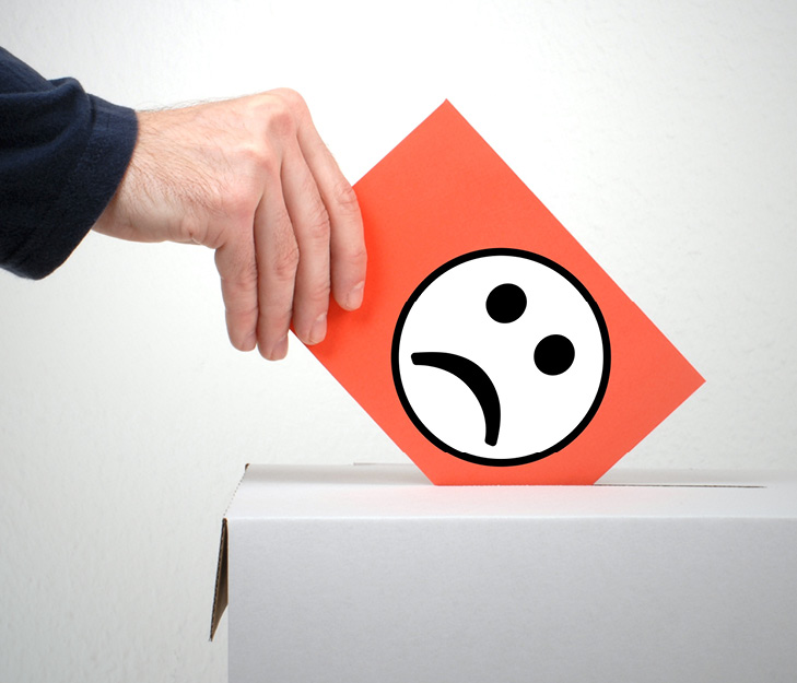 hand putting a card with a smiley face icon with downturned mouth into a complaint box