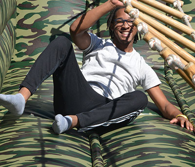 laughing student after falling off horizontal bamboo and rope ladder challenge 