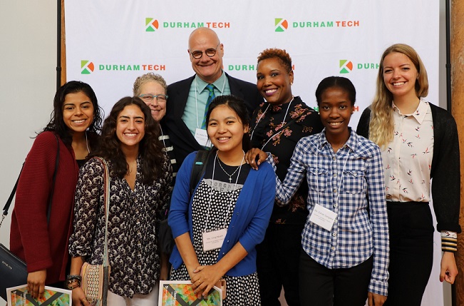 group of six students that received scholarship stand with two donors in front of durham tech backdrop