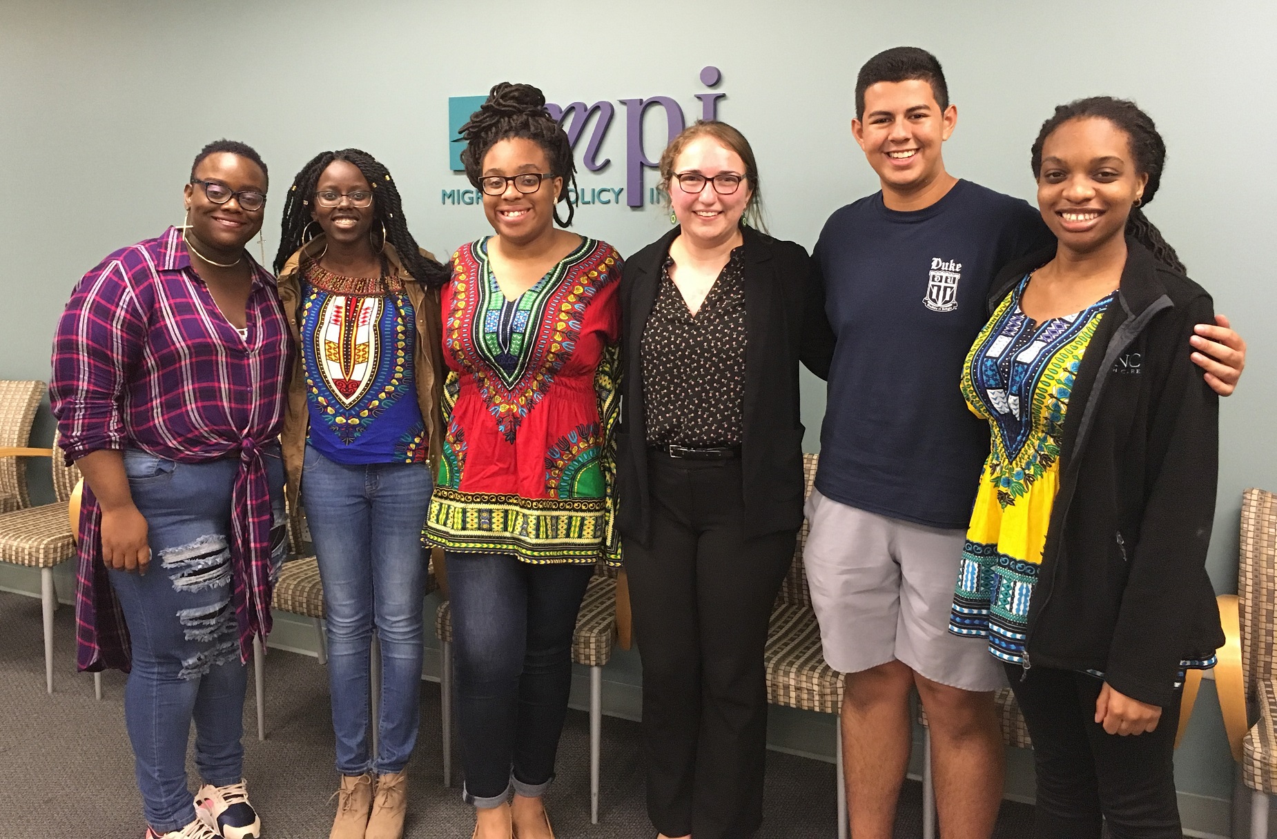 group photo of six students standing in front of think tank logo
