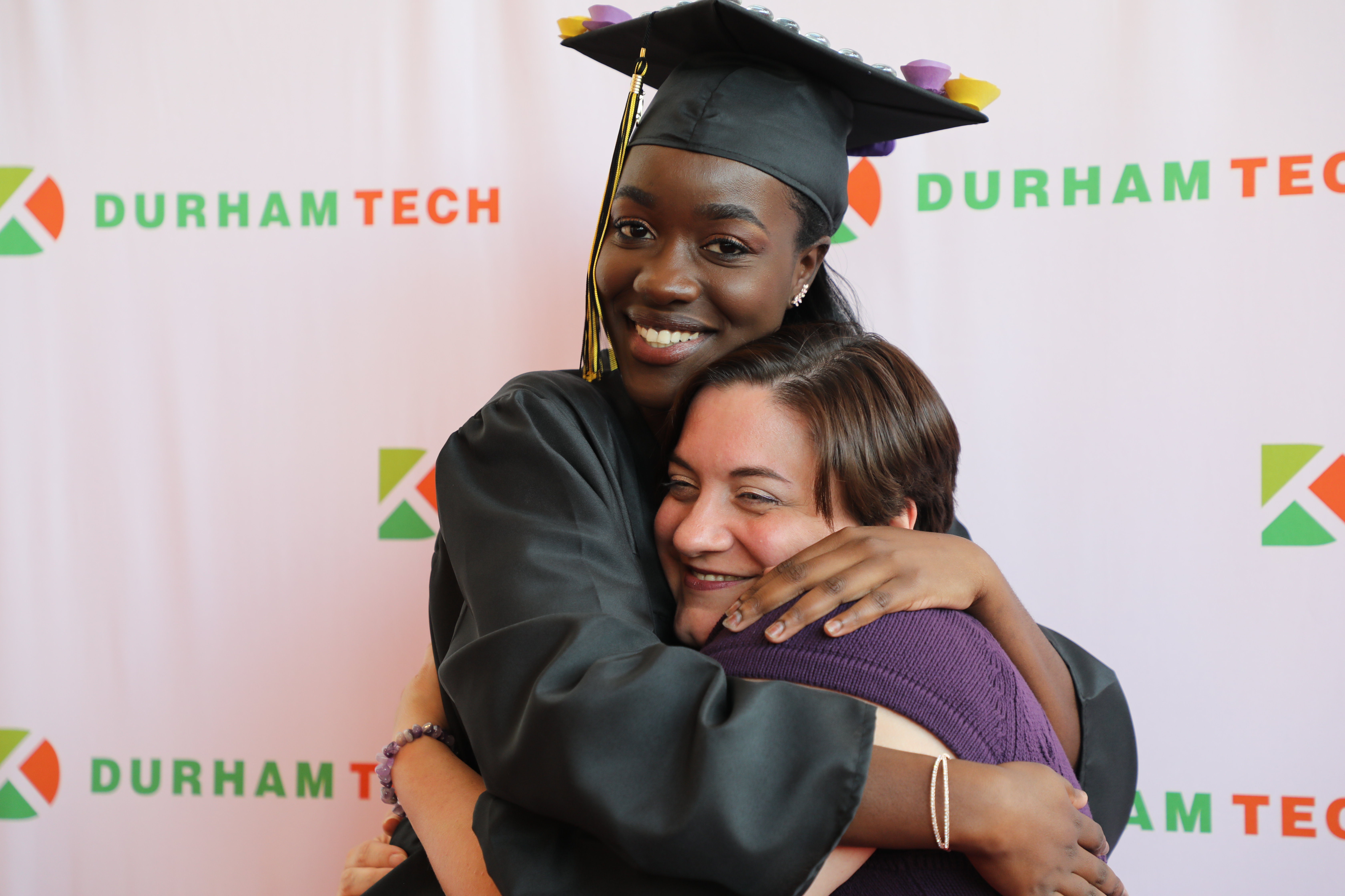 graduate being hugged by staff member 