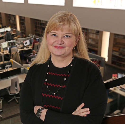 robyn standing in front of newsroom with arms crossed