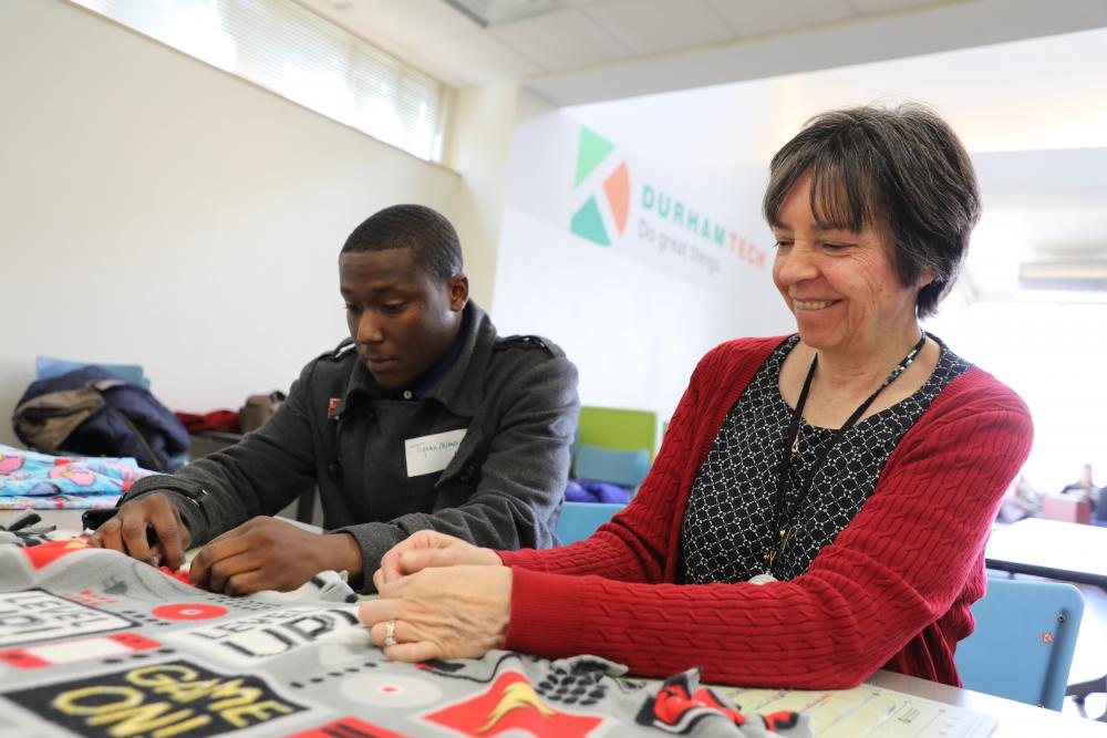 faculty student make fleece blanket for children at MLK event 