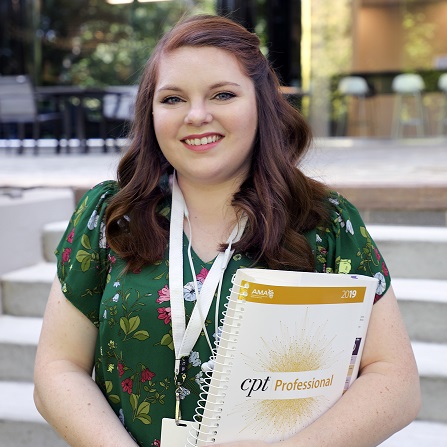 marissa holding book and smiling at camera