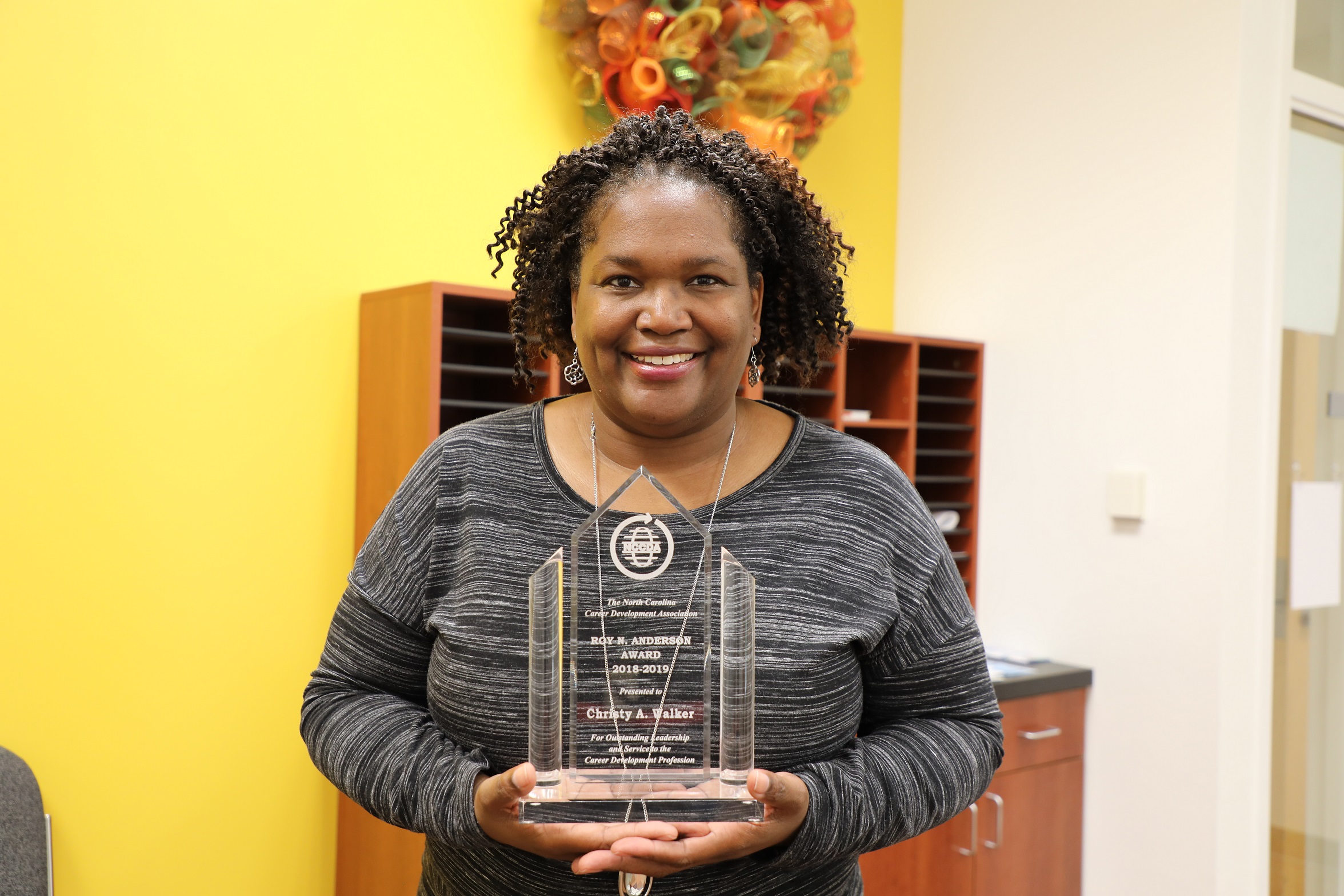 christy holding award and smiling