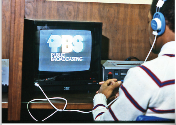 person looking at old television that says PBS broadcasting