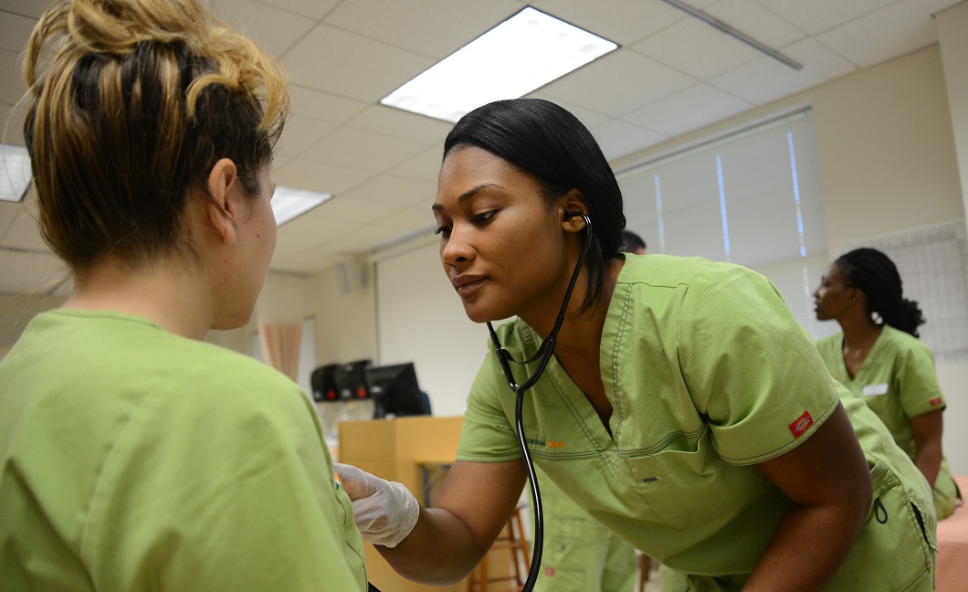 student using stethescope on another student 