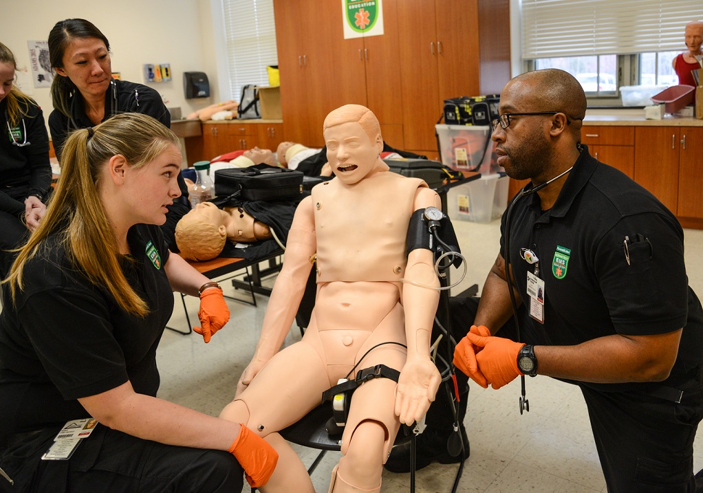 two students practice scenario on mannequin