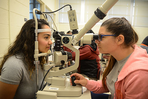 An Opticianry student practices using a tonometer to check for glaucoma