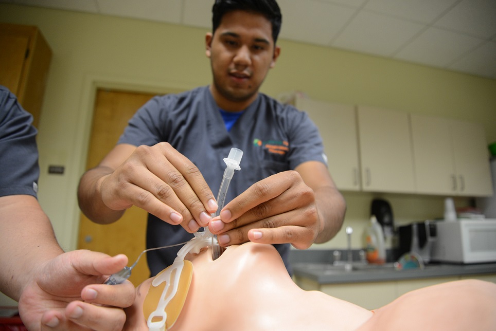 student placing intubation tube into mannequins mouth