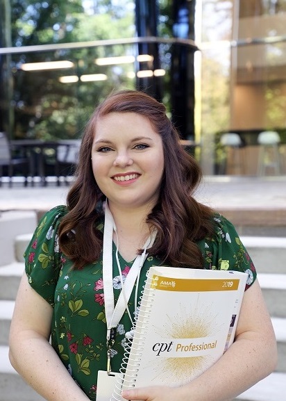 marissa holding book and smiling at camera