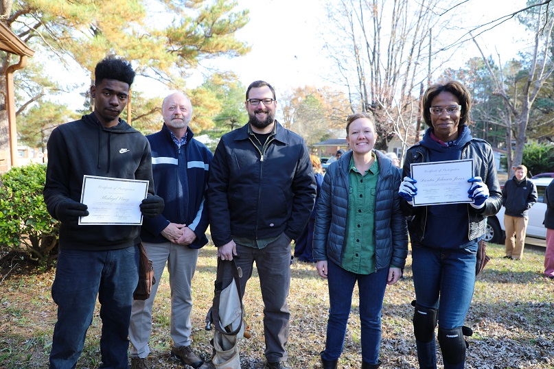 three faculty and two students standing together smiling and holding certificates