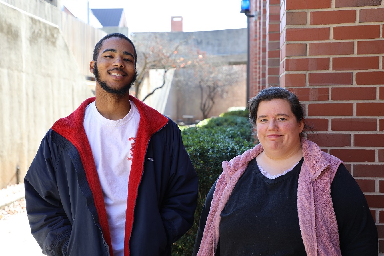 two students standing and smiing at camera