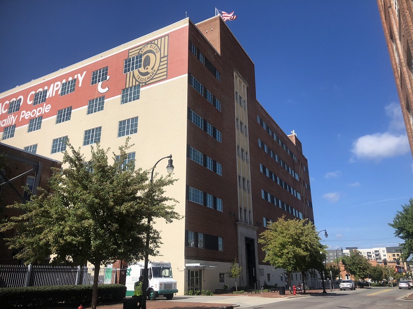 tall building on main street with two trees on either side, blue skies