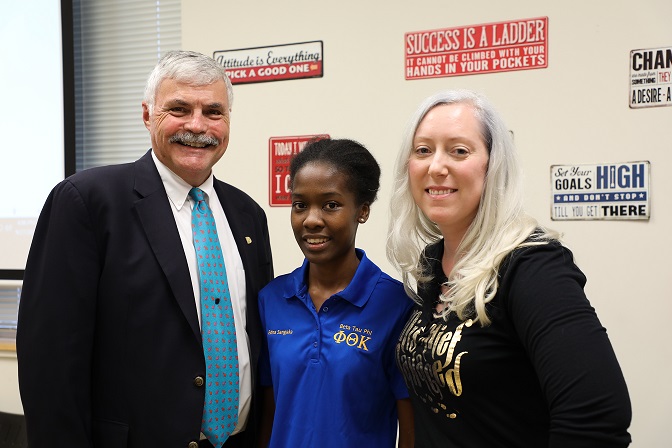 dr. ingram on left and two scholarship recipients smiling next to him