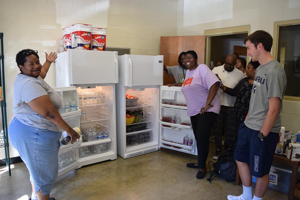 people standing in front of two fridges and excited