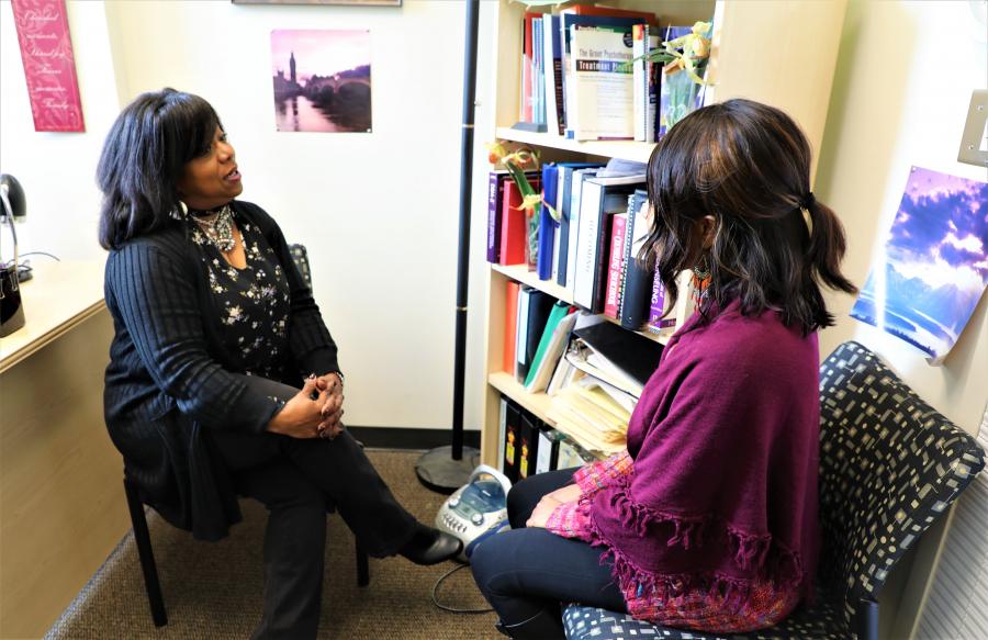 two people sitting in a room talking to each other