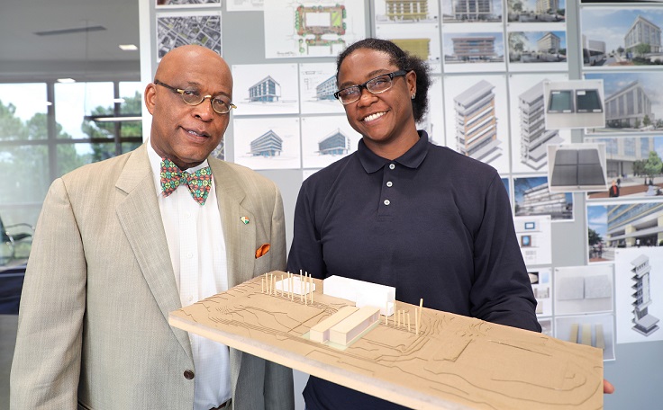 Kevin Montgomery and Carmen Williams holding future model of campus and smiling 