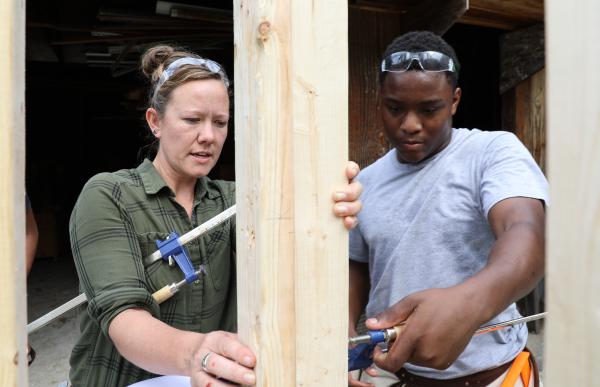 two people behind wood framing