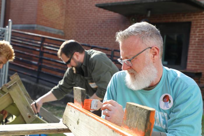 man painting picnic table