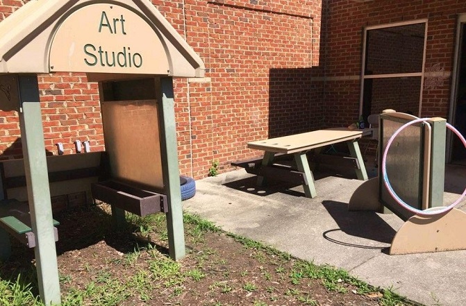 before photo of play area with art studio and table in background