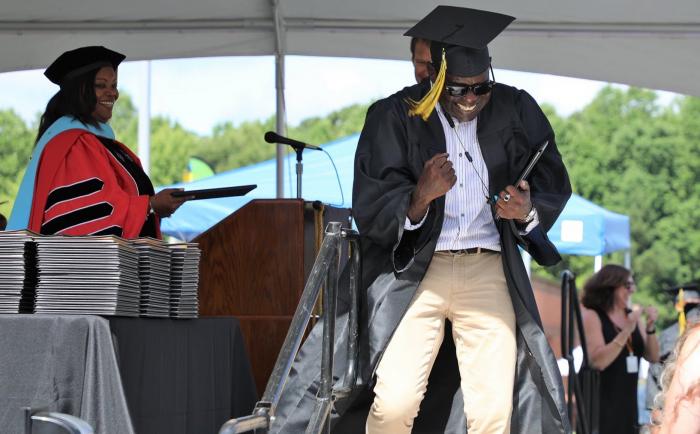 man excited after walking across graduation stage