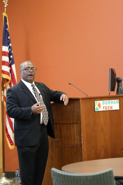 michael hughes standing next to podium speaking