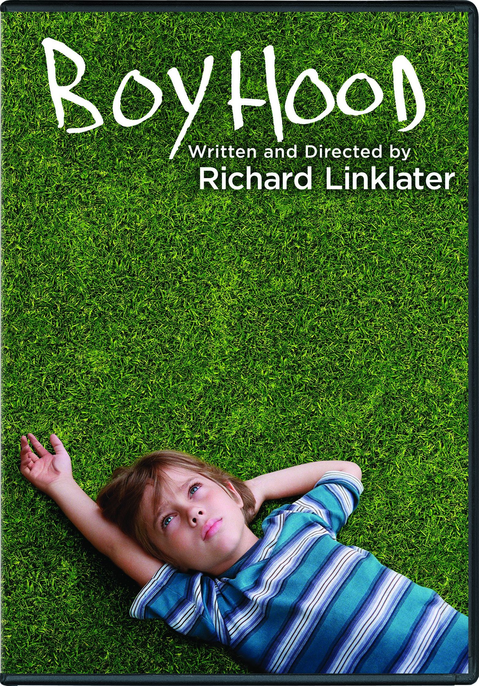 A young boy lying on grass gazing up at the sky.