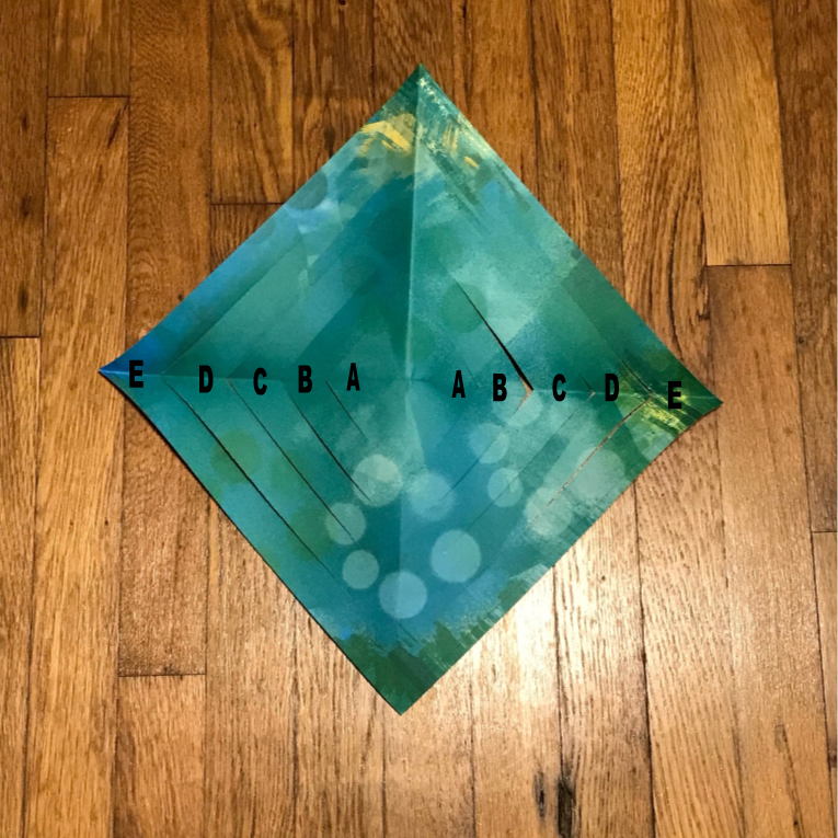 Unfolded scrapbook paper with cuts visible