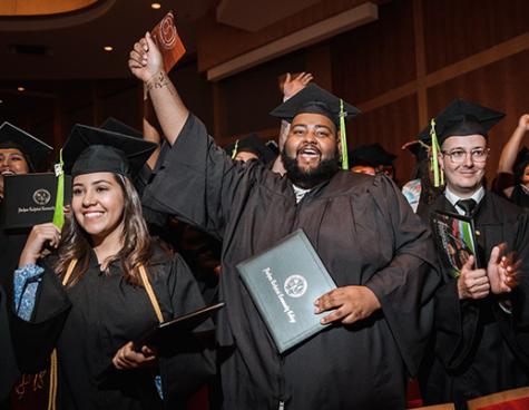 graduating students cheering at Commencement