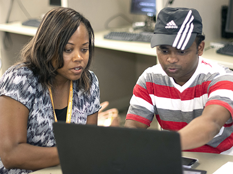 student meets with instructor discussing computer content