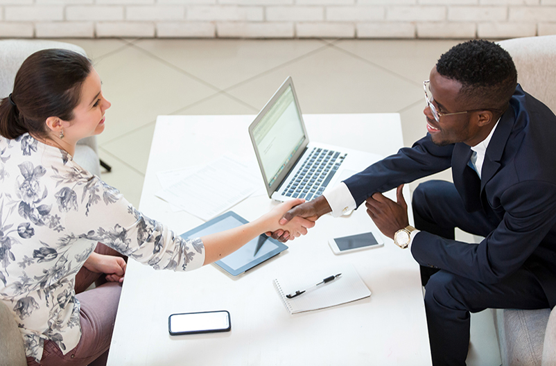 A student shakes hands with a recruiter during an interview