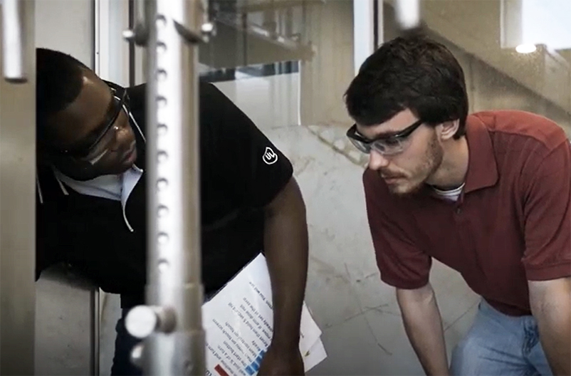 A mentor shows a student their machinery