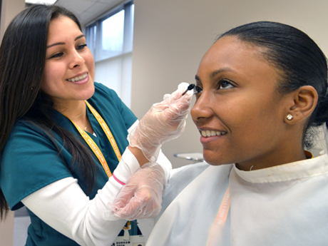 esthetics student applies macara to client in esthetics spa