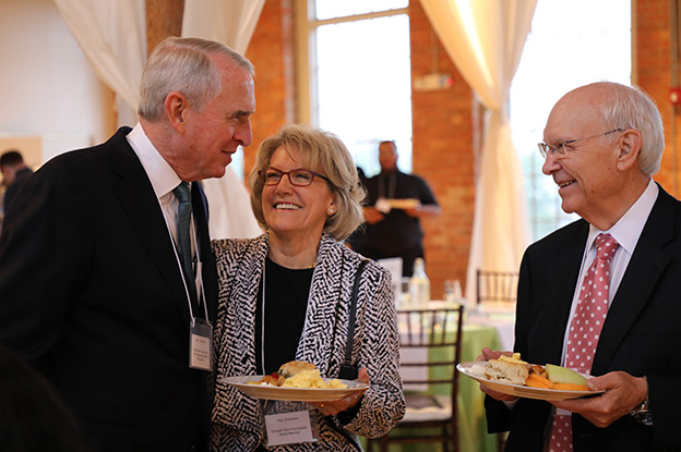 three board members laugh at Scholarship breakfast