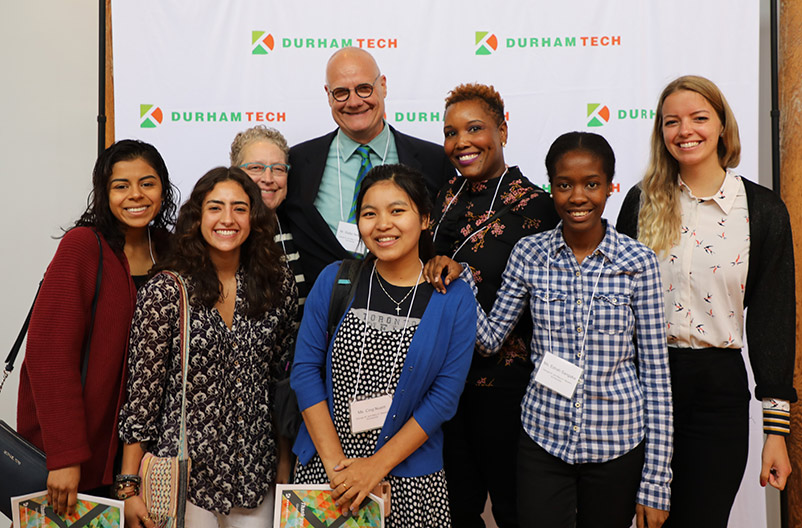 Donor and board member poses with a group of scholarship recipients